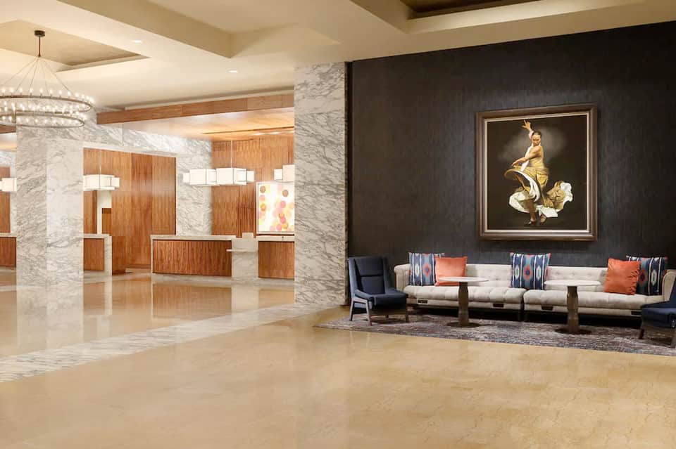Modern hotel lobby with marble columns, wooden accents, and contemporary furniture