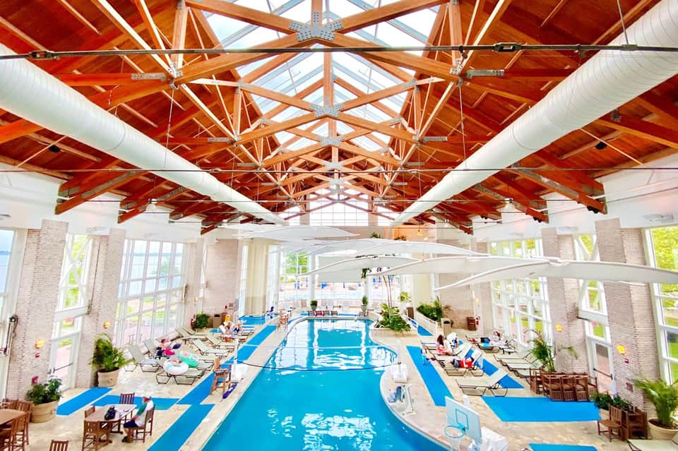 Indoor Olympic-length lap pool with exposed wooden beam ceiling and large windows