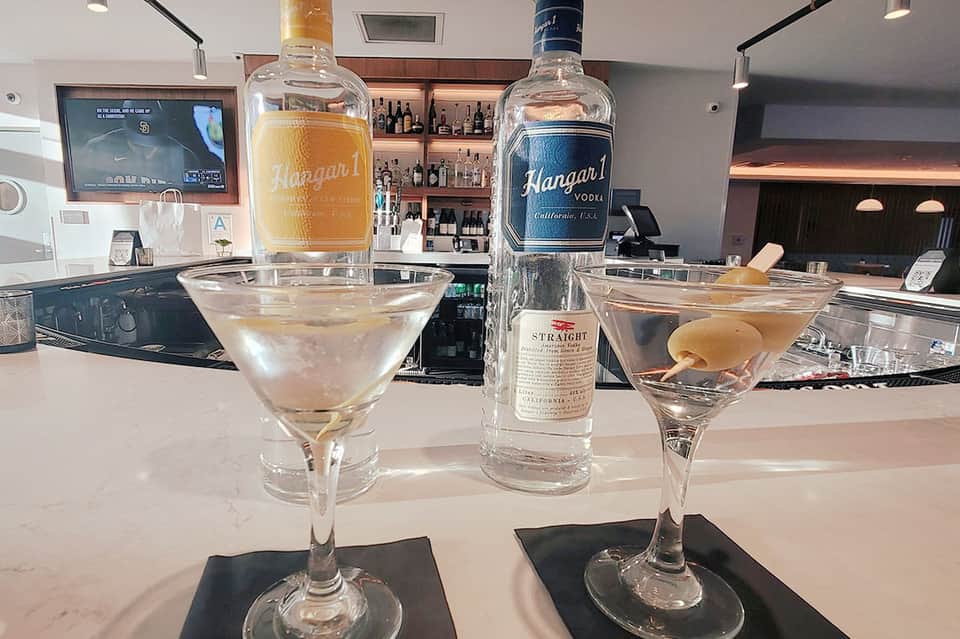 Craft cocktails at resort bar with Hangar 1 vodka bottles and spirits displayed behind counter