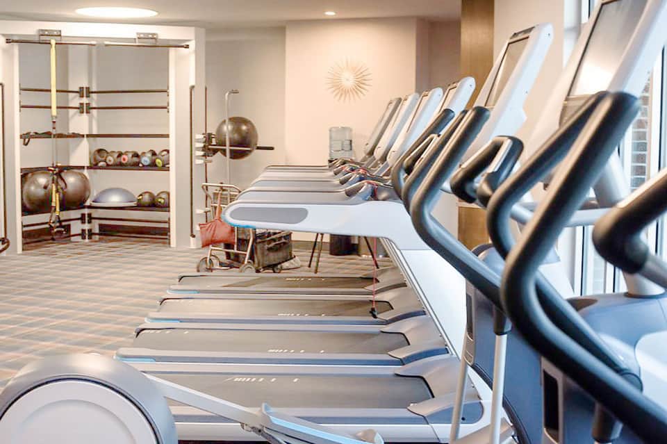 State-of-the-art fitness center with treadmills, exercise equipment, and mirrored walls