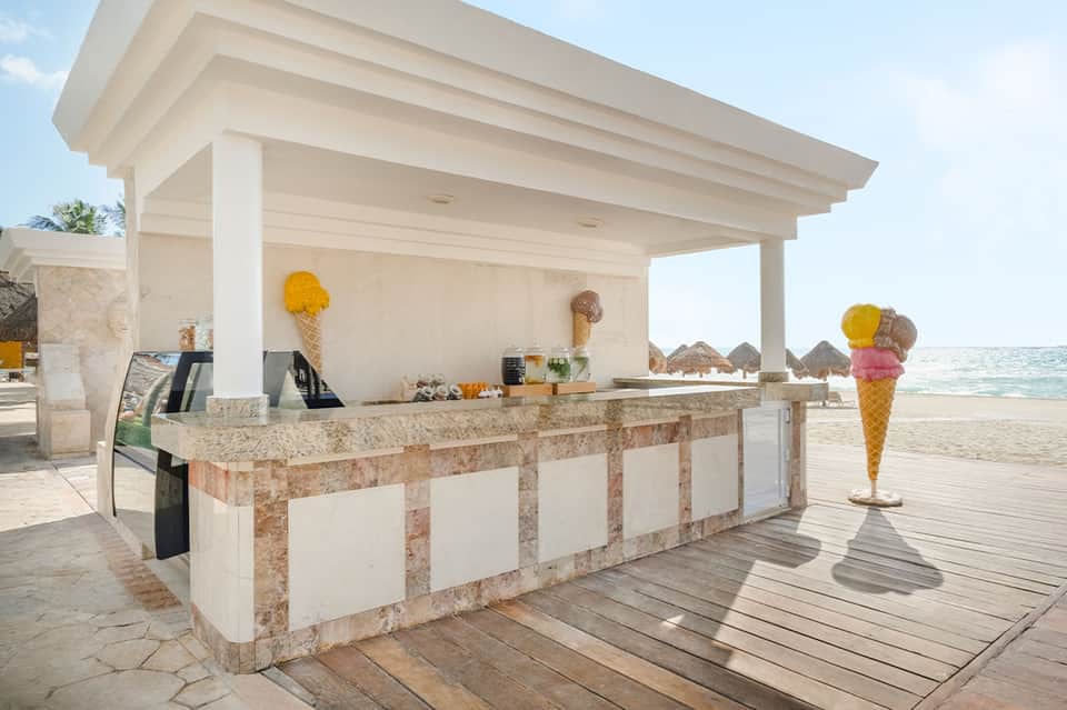 Beachside ice cream stand with white pergola, granite countertop, and ocean backdrop