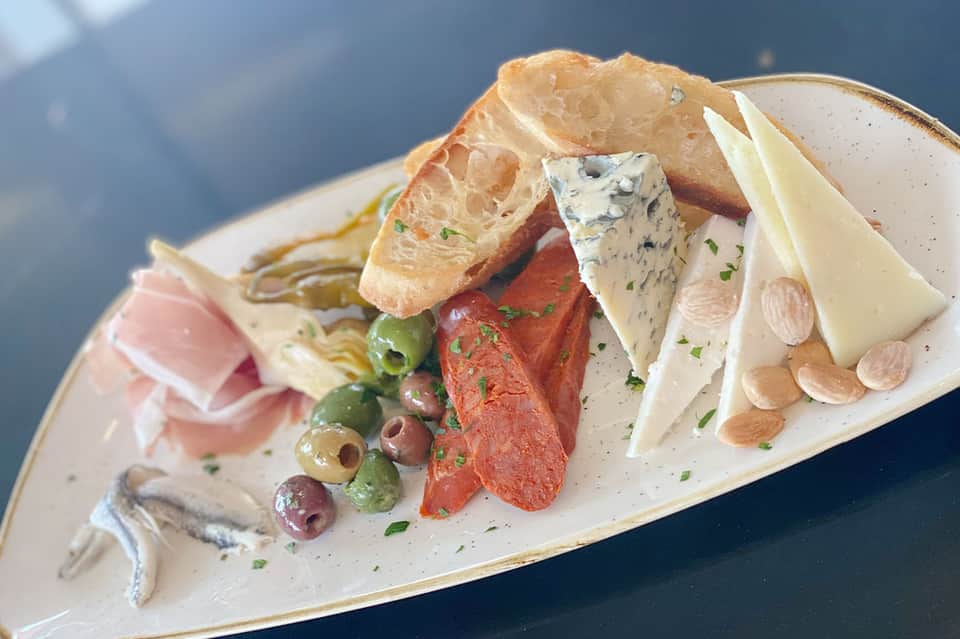 Gourmet charcuterie board with cured meats, cheeses, olives, and almonds
