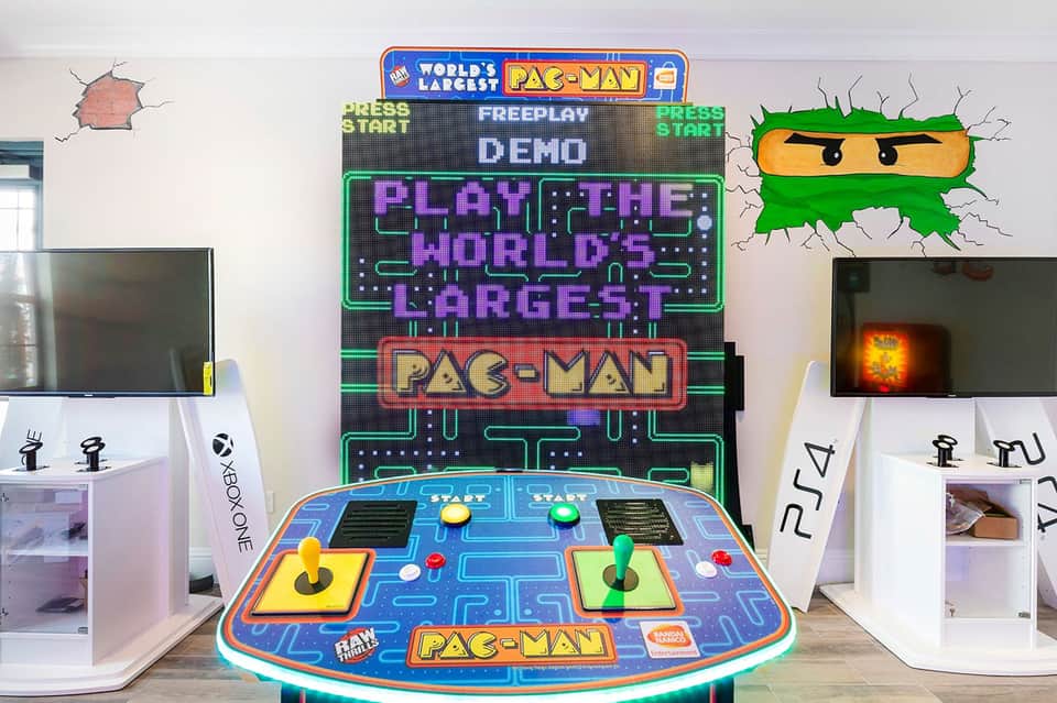Vintage Pac-Man arcade game in entertainment room with console displays