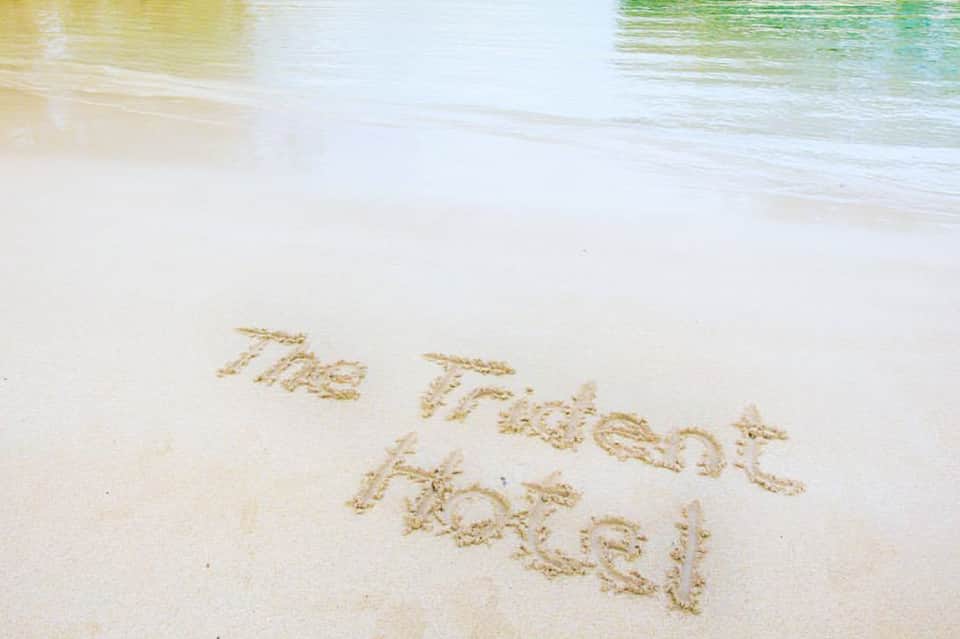 Sandy beach with text 'The Perfect Moment' written in sand, turquoise water visible in background