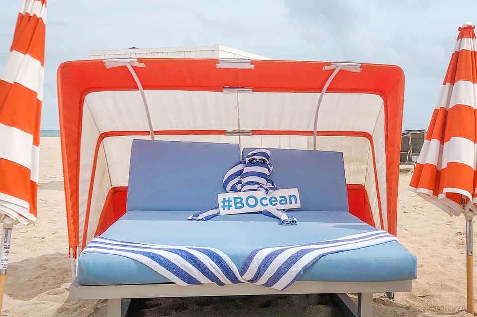 Beach cabana bed with red and white striped canopy and blue #BOcean branded bedding