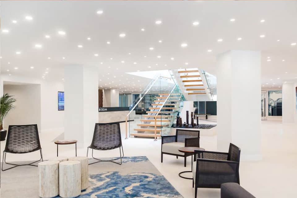 Bright modern lobby with staircase, contemporary seating, and minimalist design