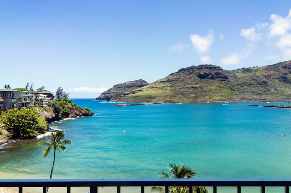 Turquoise ocean bay with green hillside and beachfront resort buildings