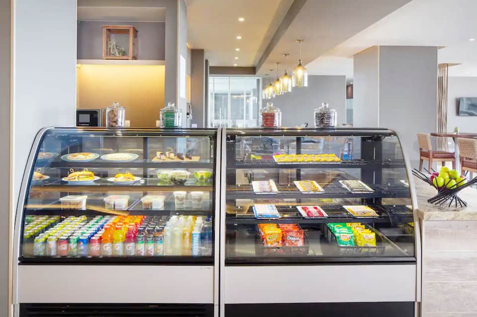 Modern hotel bakery display cases filled with pastries, desserts, and beverages