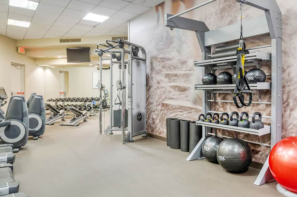 Modern fitness center with cardio equipment, weights, kettlebells, and exercise machines