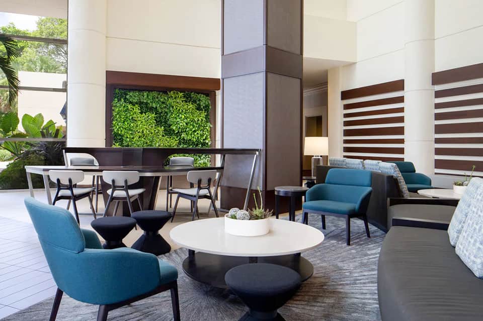 Modern hotel lobby with blue armchairs, living wall, and contemporary furnishings