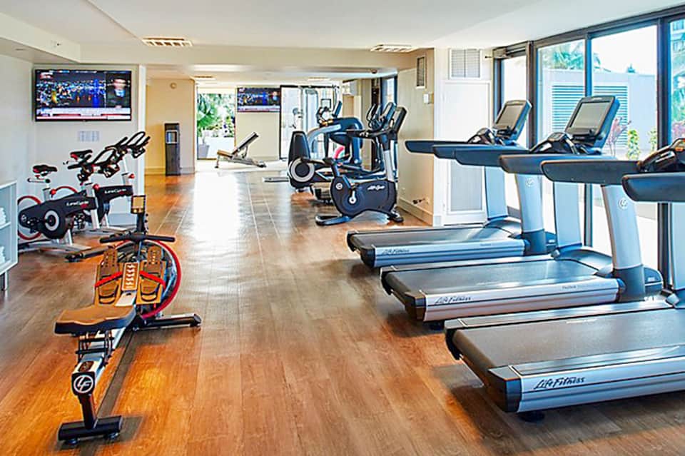 Bright fitness center with treadmills, stationary bikes, and cardio equipment