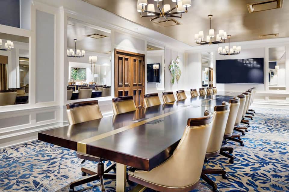 Elegant conference room with long dark table, cream chairs, and modern lighting