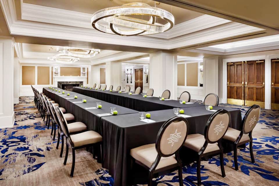 Elegant hotel conference room with long black table and cream-colored chairs