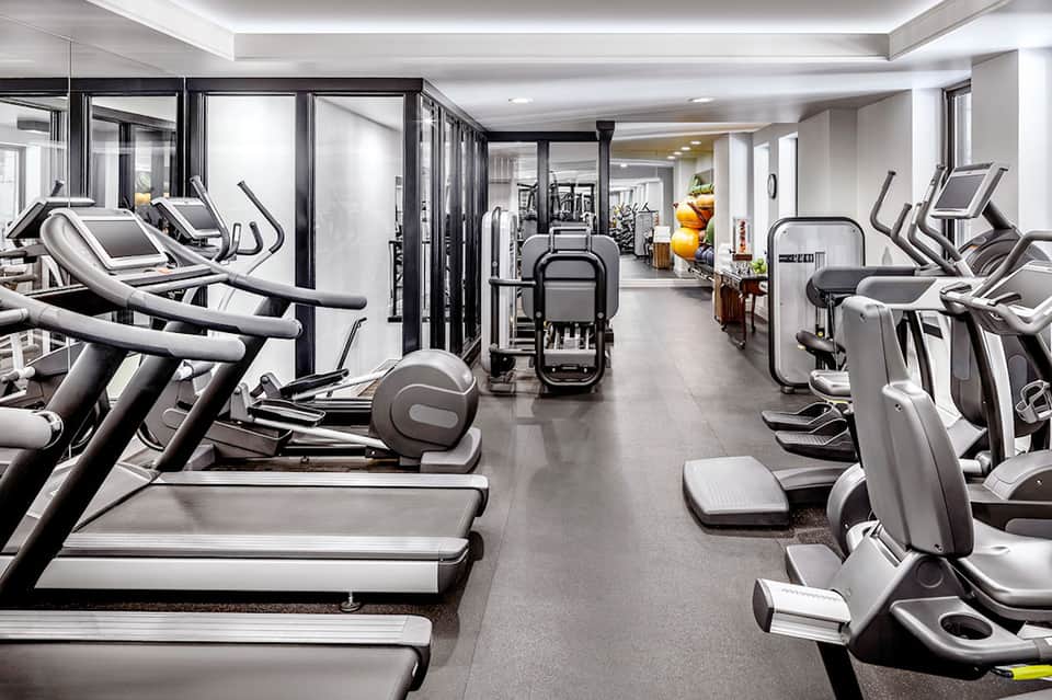 Modern fitness center with rows of treadmills, elliptical machines, and exercise equipment