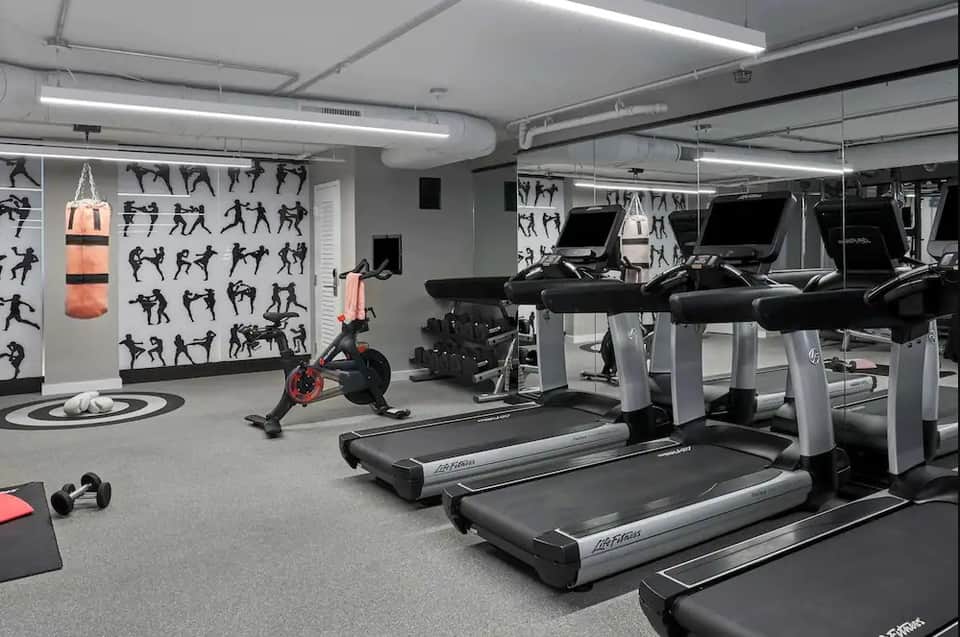 Contemporary fitness center with treadmills, exercise bike, boxing bag, and motivational wall graphics