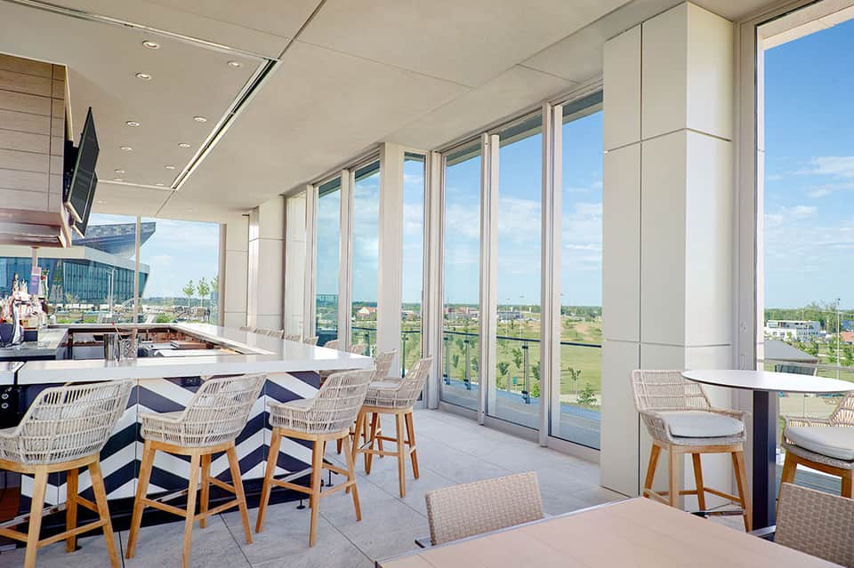 Contemporary restaurant interior with floor-to-ceiling windows overlooking scenic landscape and blue sky