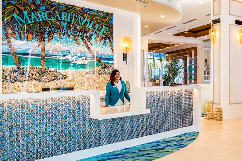 Margaritaville Nassau Bahamas resort reception desk with tropical beach mural and blue mosaic tile accents