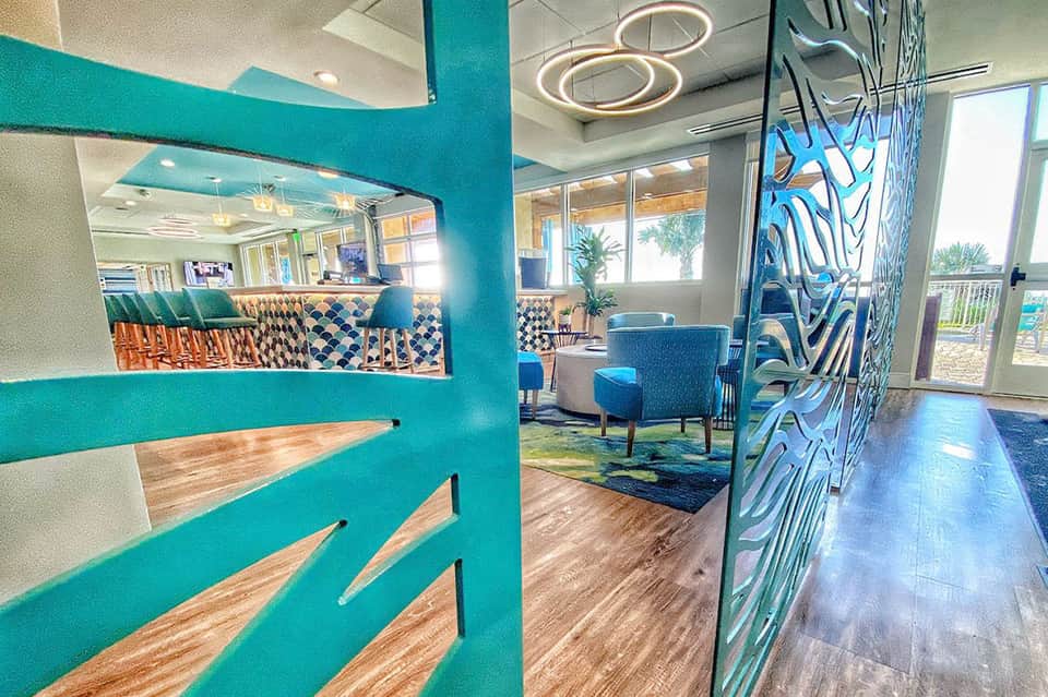 Modern hotel lobby interior with turquoise columns, geometric patterns, and contemporary seating