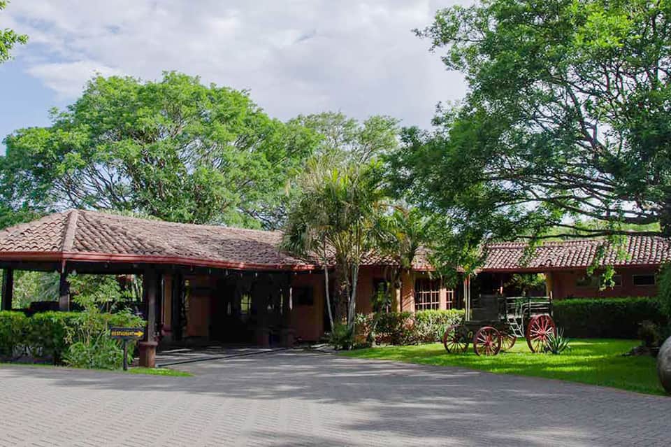 Colonial-style hacienda with terra cotta roof and manicured grounds