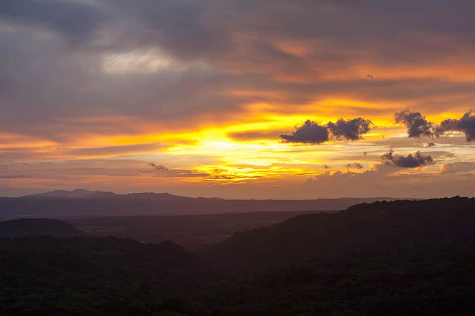 Golden sunset over mountainous landscape with dramatic clouds
