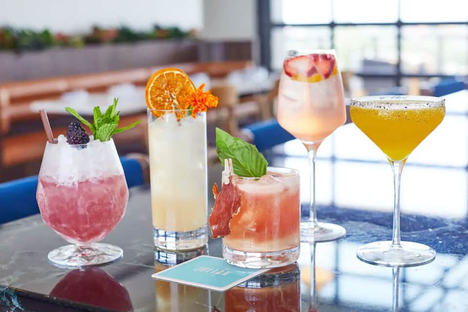 Colorful cocktails on a rooftop bar with ocean view and decorative umbrellas