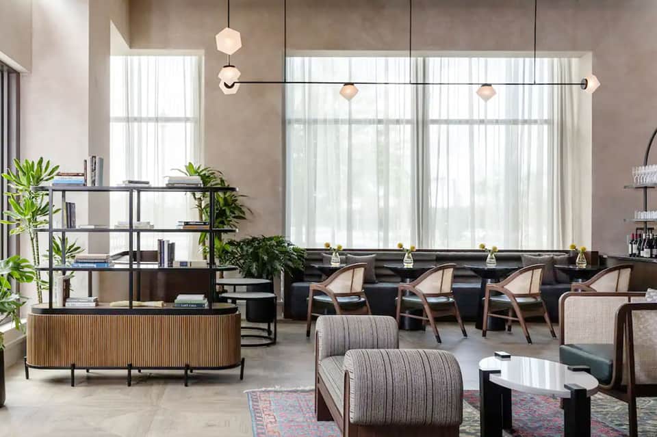 Modern hotel lounge with contemporary furniture, large windows, and natural lighting