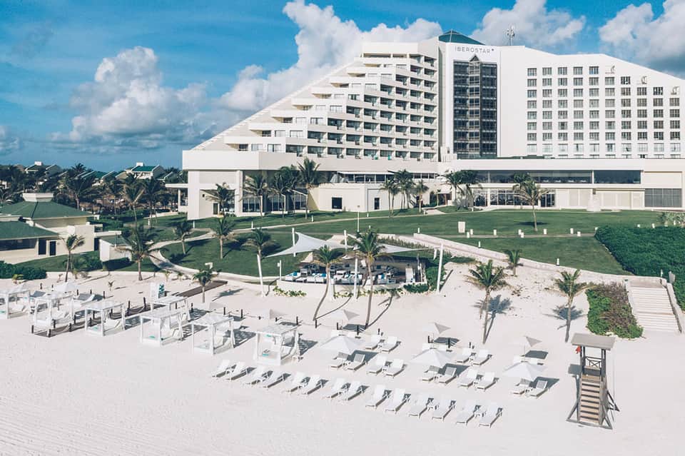 Beachfront Iberostars hotel resort with multi-story white building, beach loungers, and ocean views