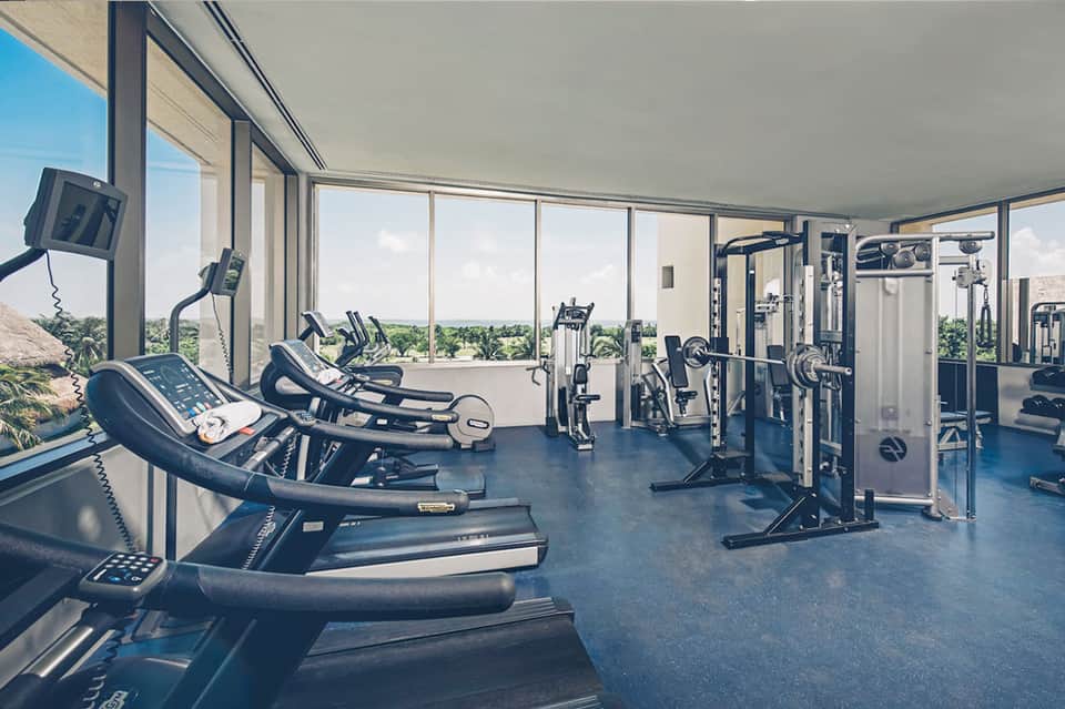Modern fitness center with treadmills and equipment overlooking landscape