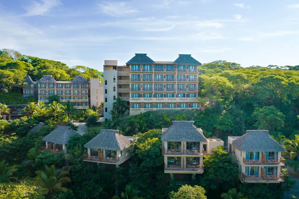 Luxury resort villas nestled in lush tropical vegetation on hillside