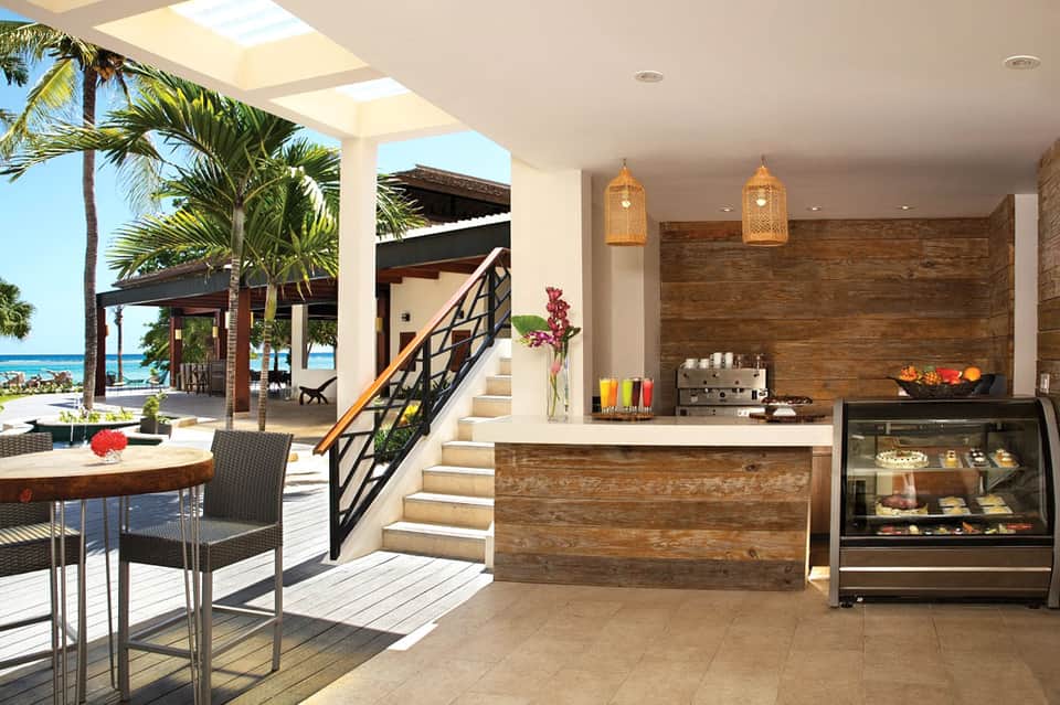 Modern beachfront bar and lounge with fireplace, ocean view, and wooden accents