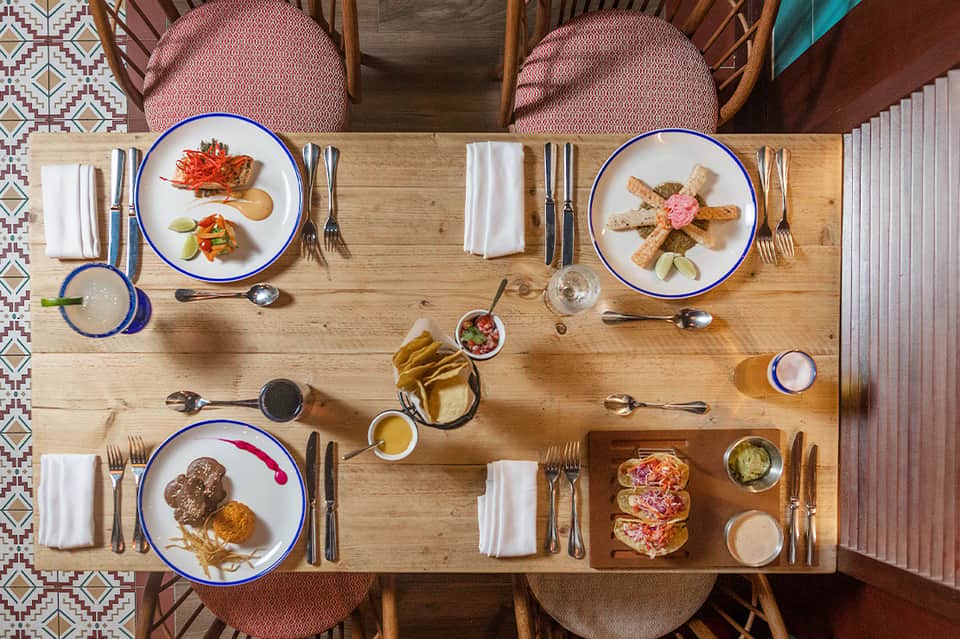 Overhead view of fine dining table settings with blue-rimmed plates and gourmet dishes