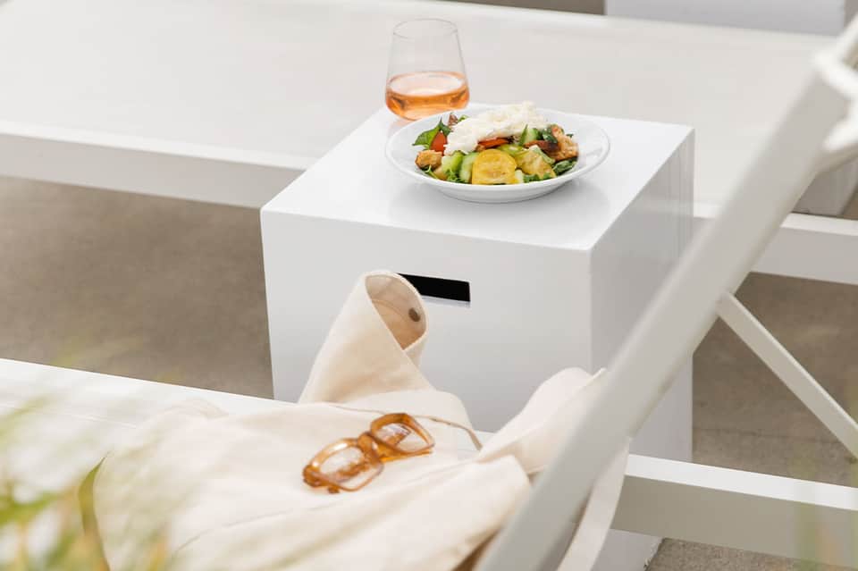 White modern balcony railing with salad plate and cocktail on small white table