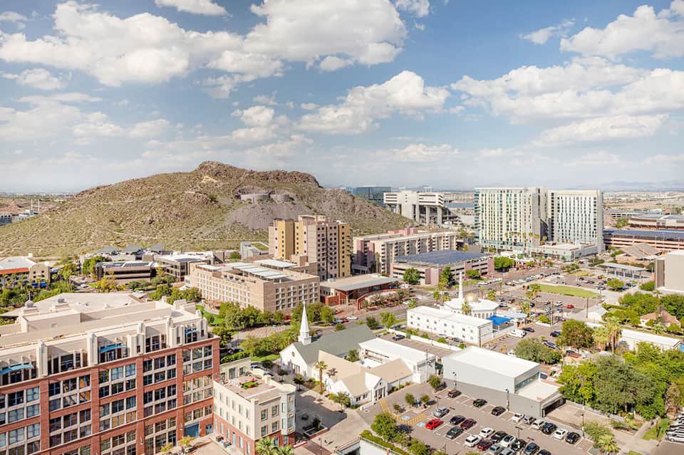 Aerial view of downtown Phoenix with mountains, modern buildings, and urban landscape