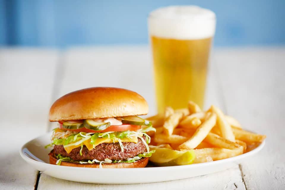 Classic cheeseburger with fresh lettuce and tomato, served with french fries and cold beer