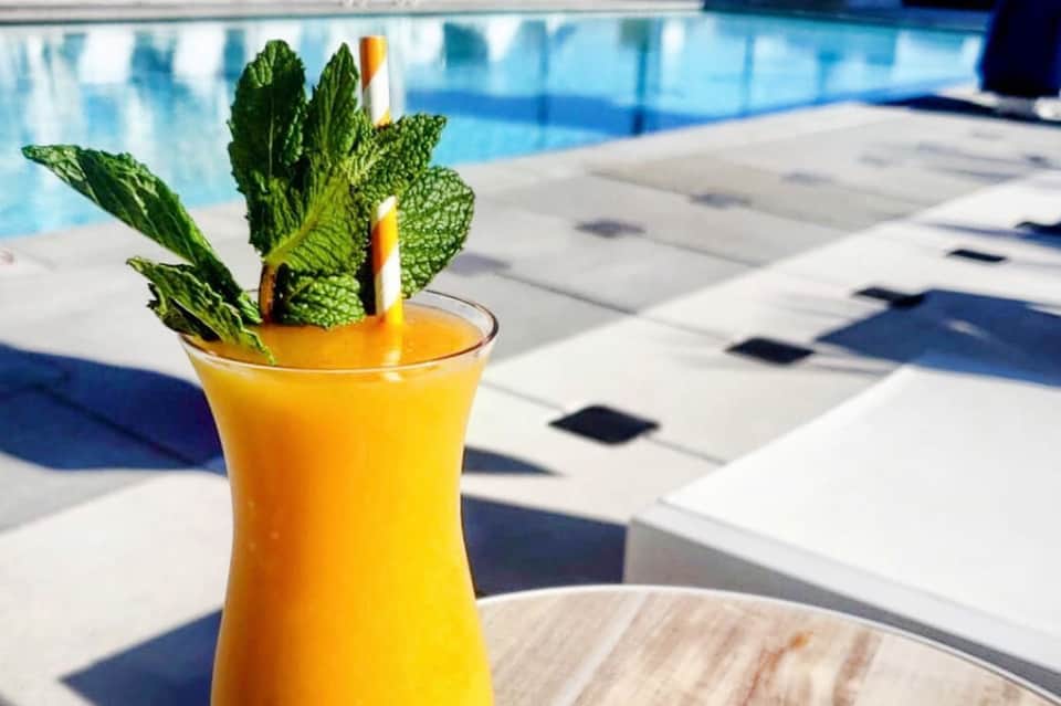 Tropical cocktail with mint garnish by resort poolside