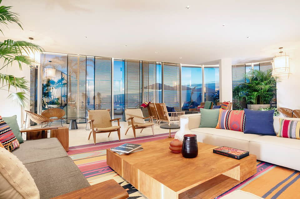 Modern living room with panoramic windows, contemporary furniture, and colorful striped accents