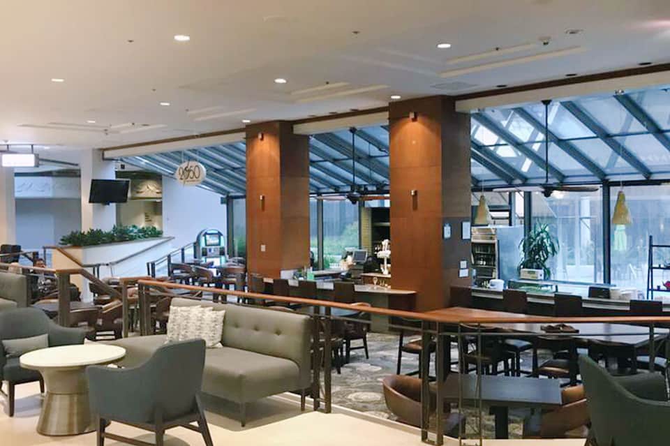 Modern resort lobby lounge with contemporary seating, skylight ceiling, and ocean views