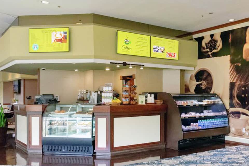Coffee shop counter with display cases, menu boards, and beverage service area