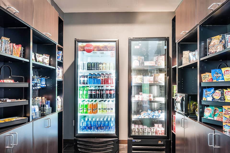 Hotel convenience store with refrigerated beverage cases and snack shelves