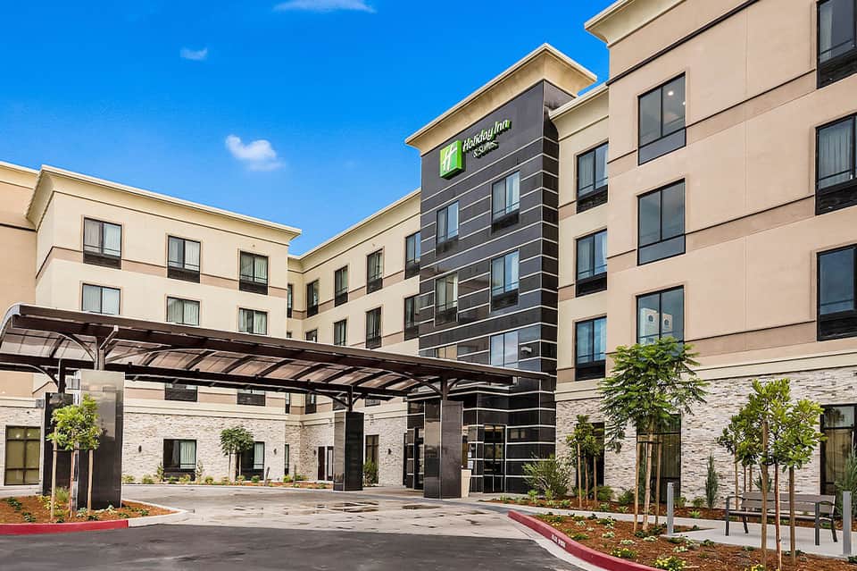 Holiday Inn hotel entrance with stone accents, landscaping, and covered portico