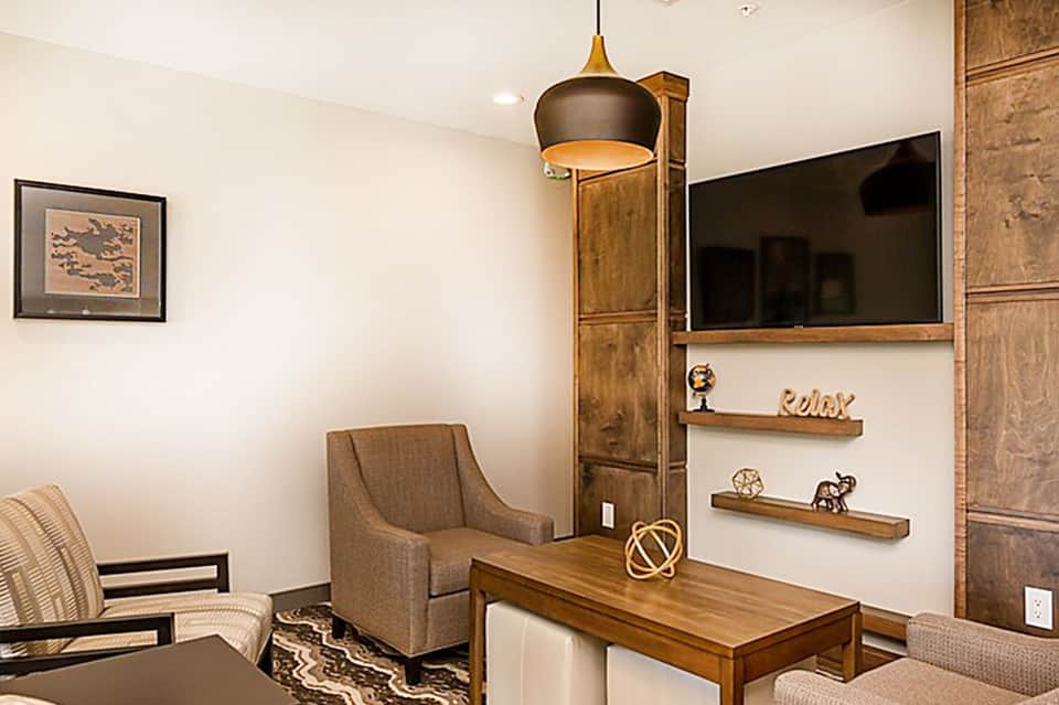 Modern hotel suite interior with wood desk, flat-screen TV, and contemporary furnishings
