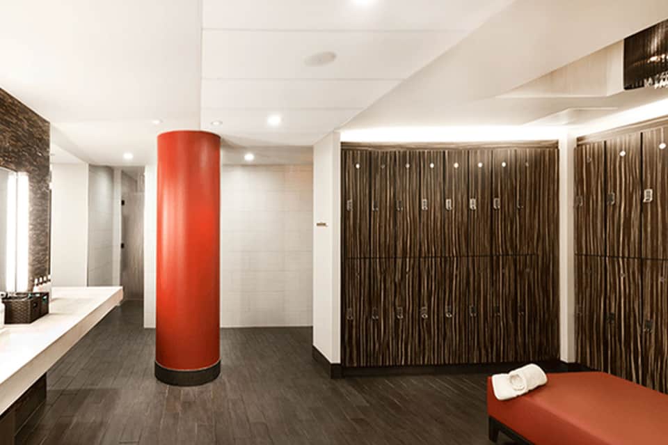 Modern locker room with red cylindrical column and wooden lockers