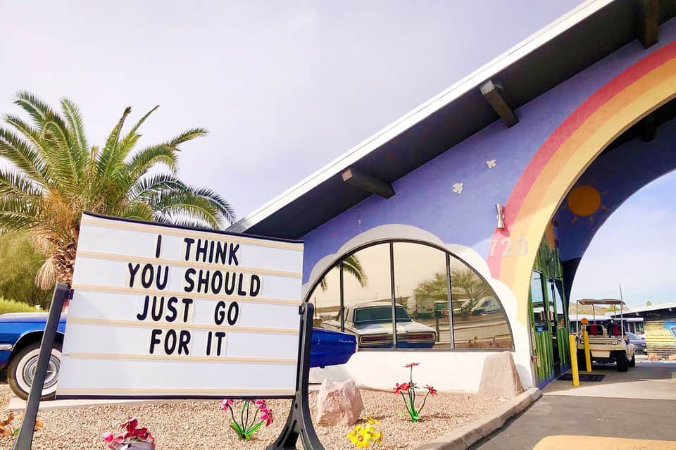 Colorful vintage-style building entrance with marquee sign reading 'I think you should just go for it'
