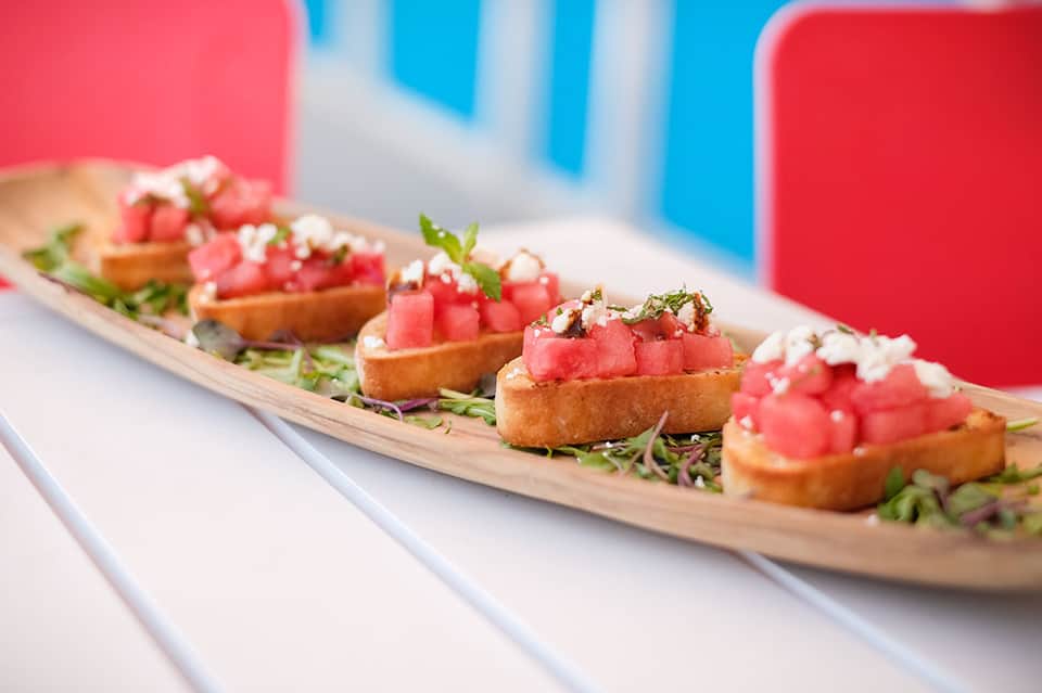 Gourmet appetizers featuring tuna tartare on crispy toast with microgreens and white sauce