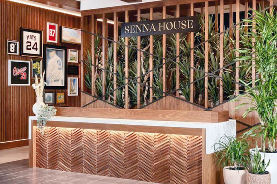 Modern hotel reception desk with wooden lattice design and sports memorabilia on walls