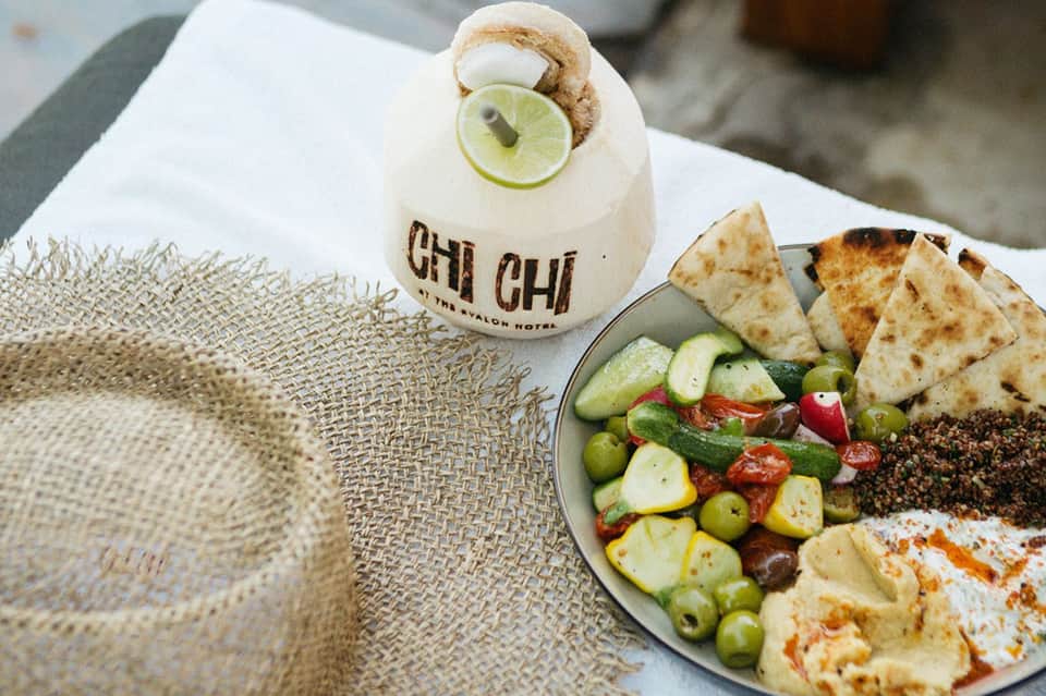 Tropical cocktail in coconut with lime, served with flatbread and vegetable appetizers
