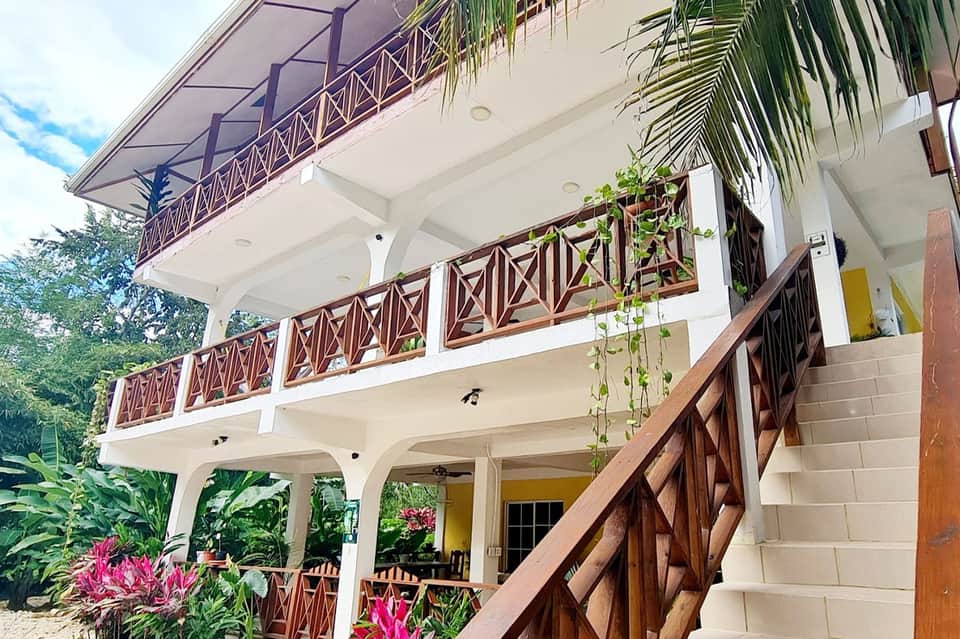 Multi-story colonial-style resort building with white walls and wooden railings