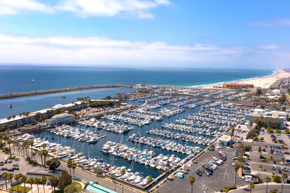 Aerial view of large marina with hundreds of moored boats and beach