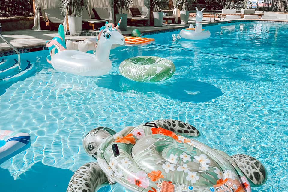 Resort pool with colorful float toys and lounge chairs
