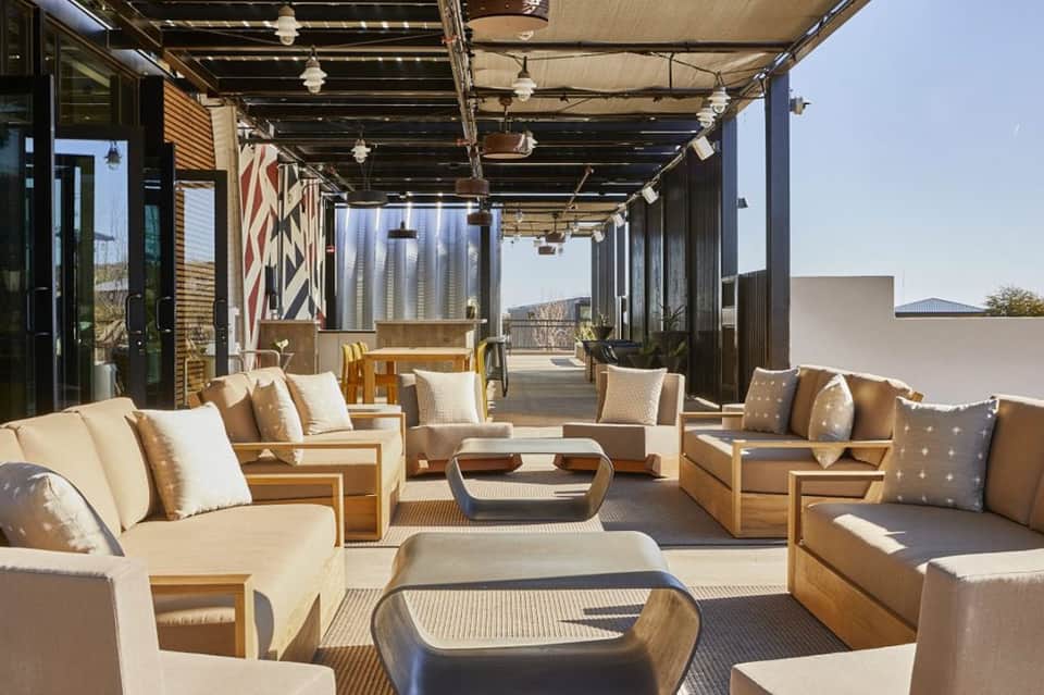 Contemporary covered terrace with tan seating, wooden furniture, and mountain views